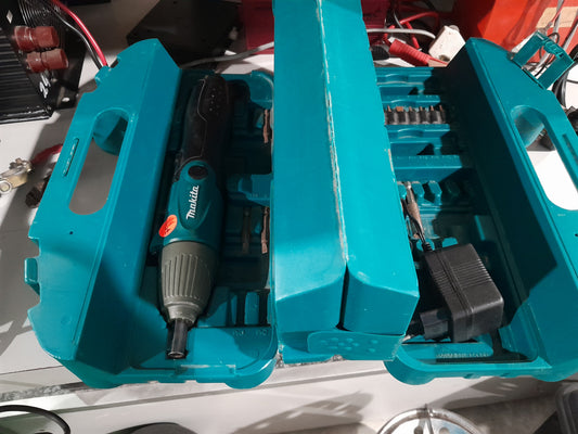 Makita cordless screwdriver with versatile design, complete with accessories, charger, and durable teal carry case.