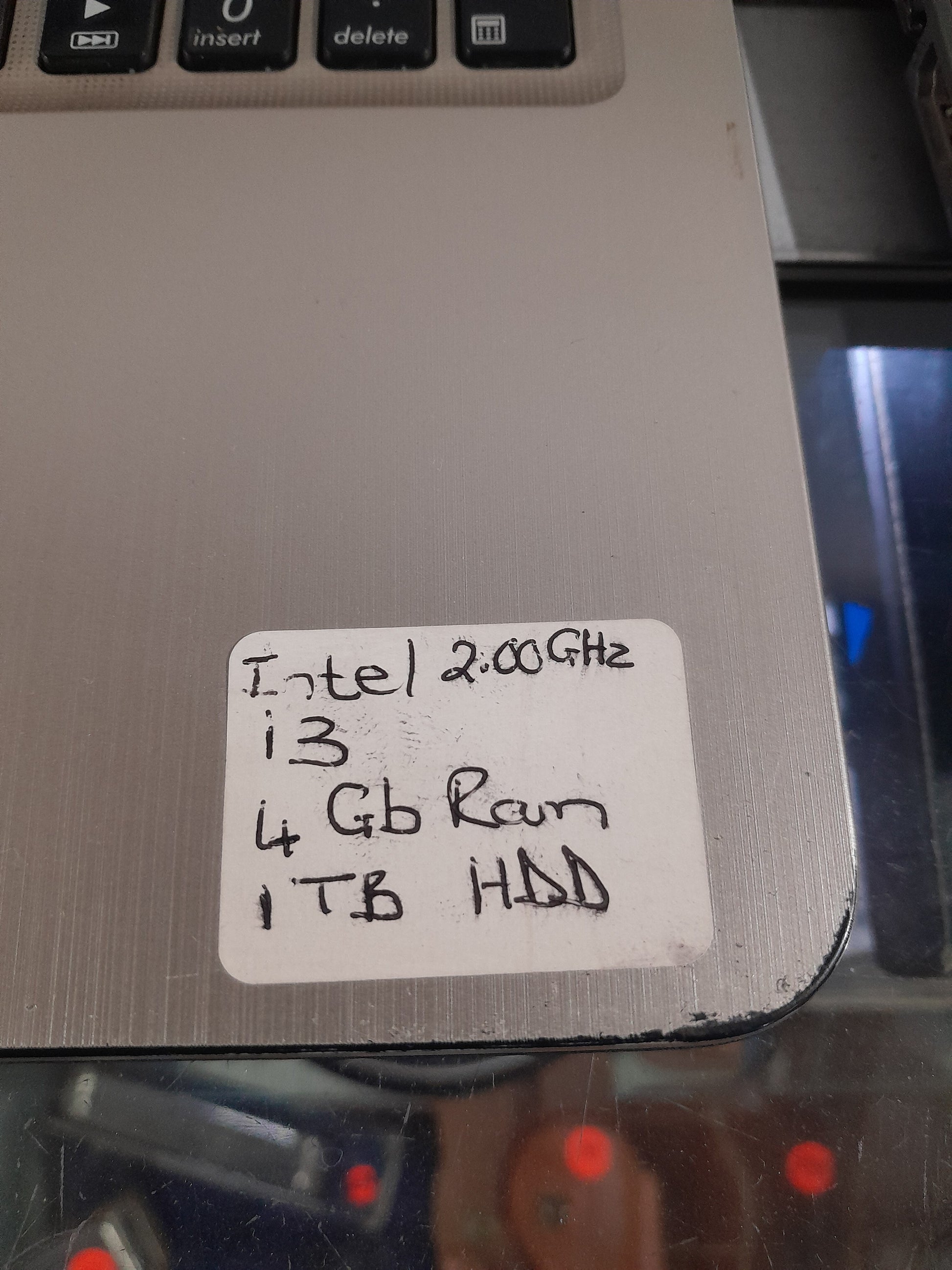 Asus i3 laptop on display in a secondhand store, featuring 1TB HDD and 4GB RAM.