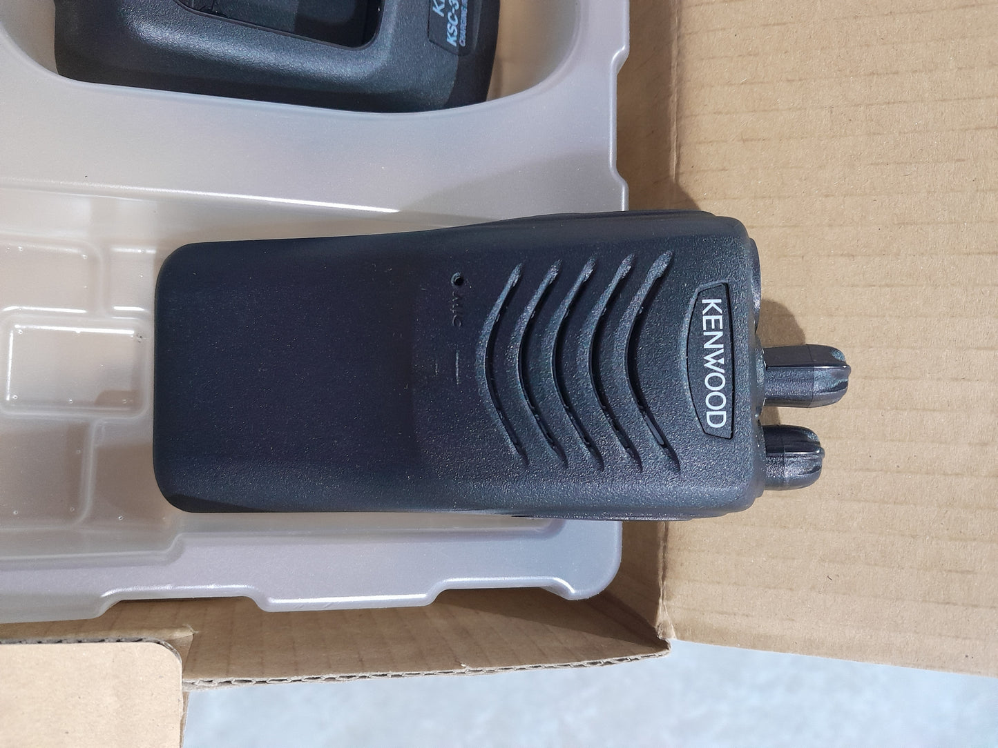 Kenwood TK-2000 radio accessories including charger and user manual, perfect for outdoor use.