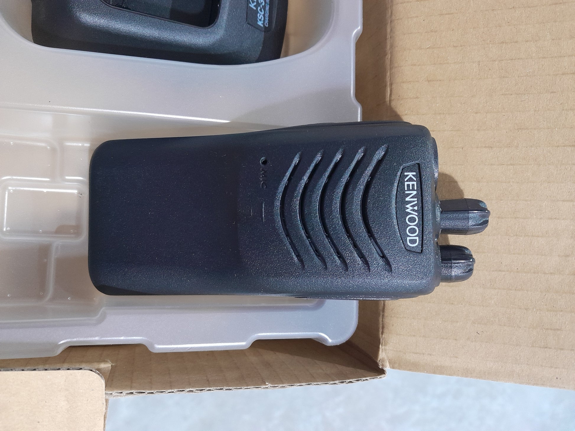Kenwood TK-2000 radio accessories including charger and user manual, perfect for outdoor use.