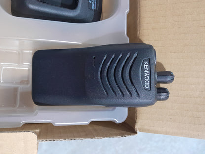 Kenwood TK-2000 radio accessories including charger and user manual, perfect for outdoor use.