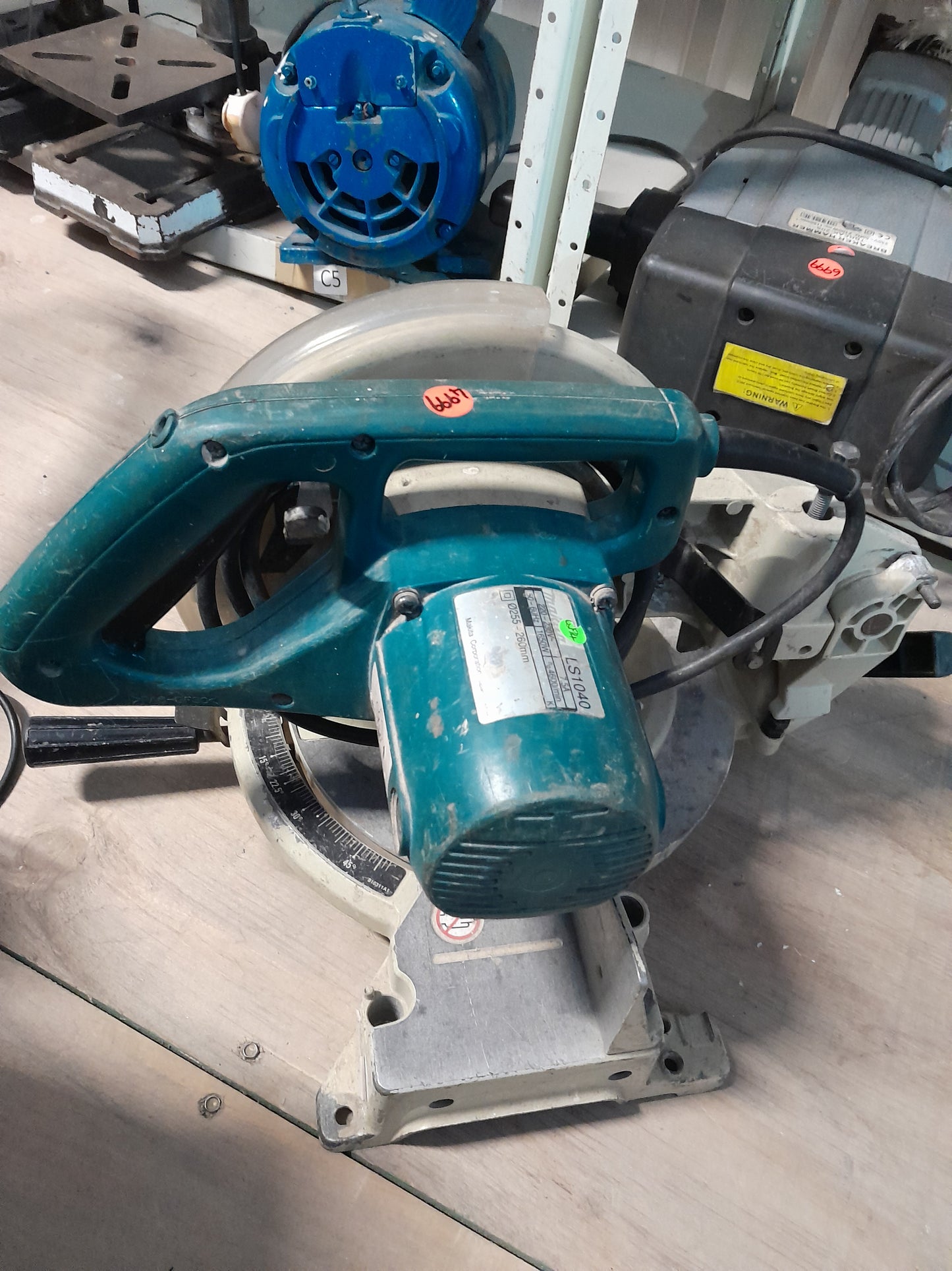Makita LS1040 compound mitre saw positioned on a workbench, showcasing its sturdy design.