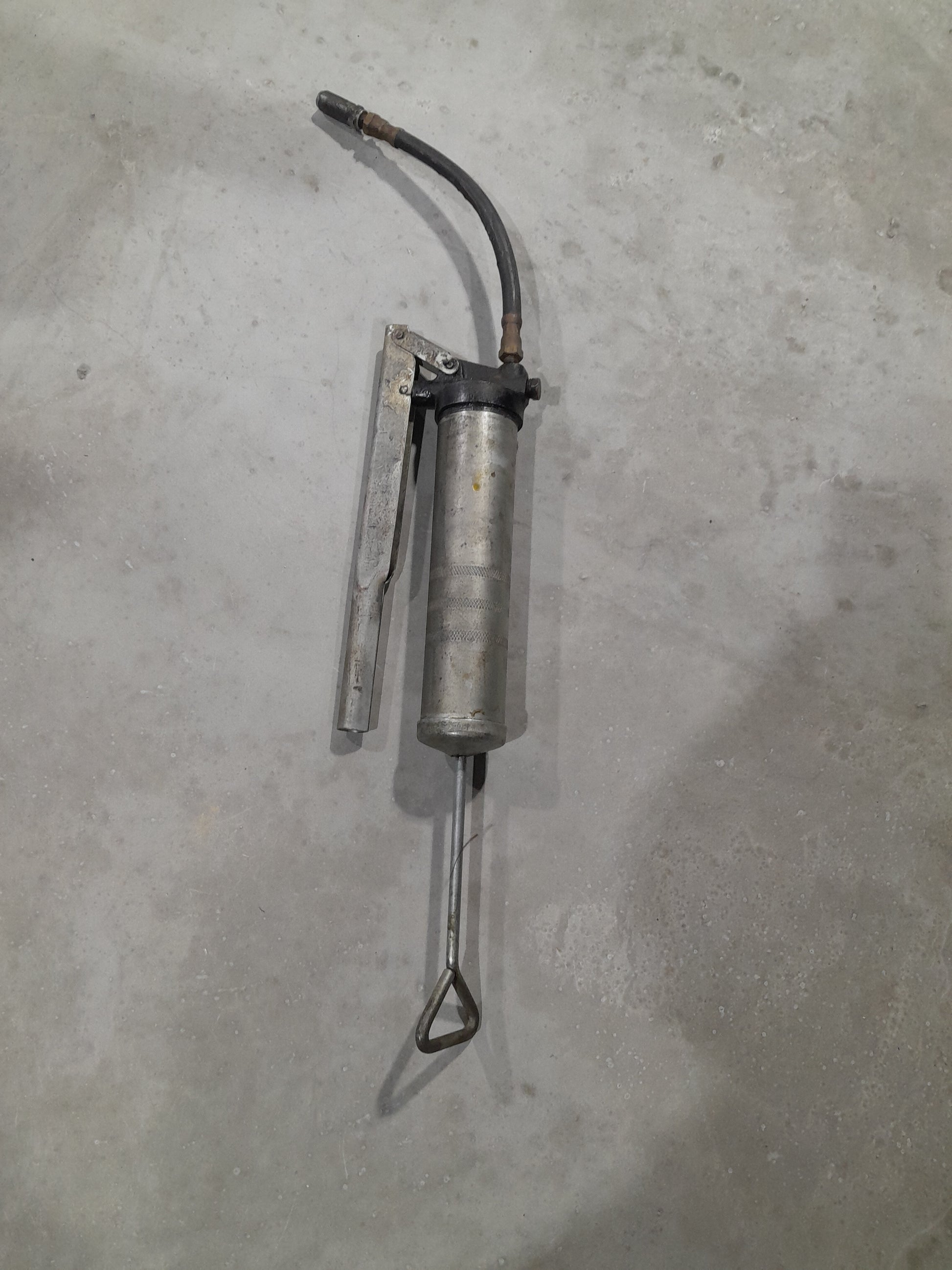 Grease gun with lever action mechanism, suitable for various maintenance applications.