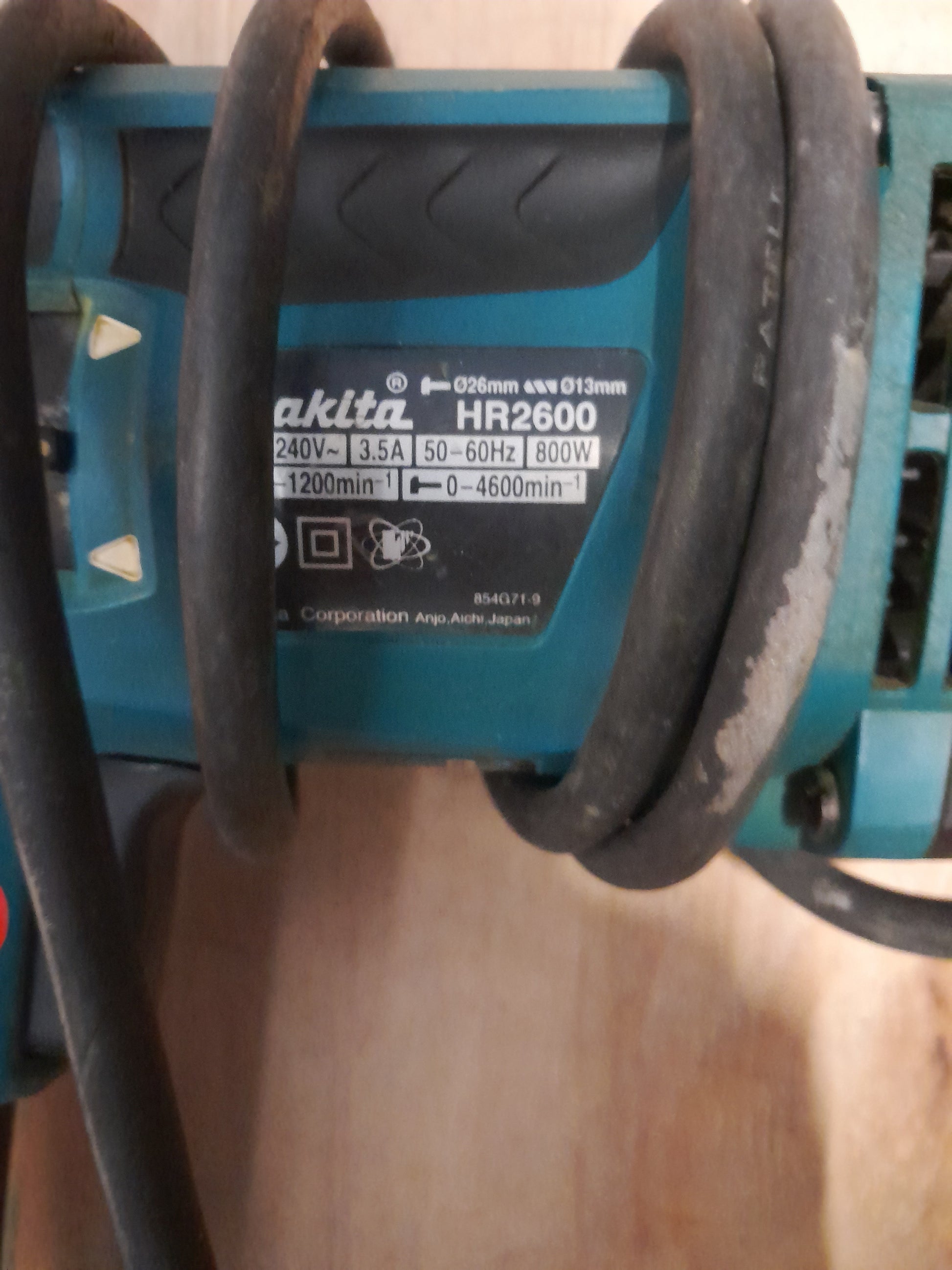 Makita HR2600 rotary hammer drill, ideal for concrete, steel, and wood applications.