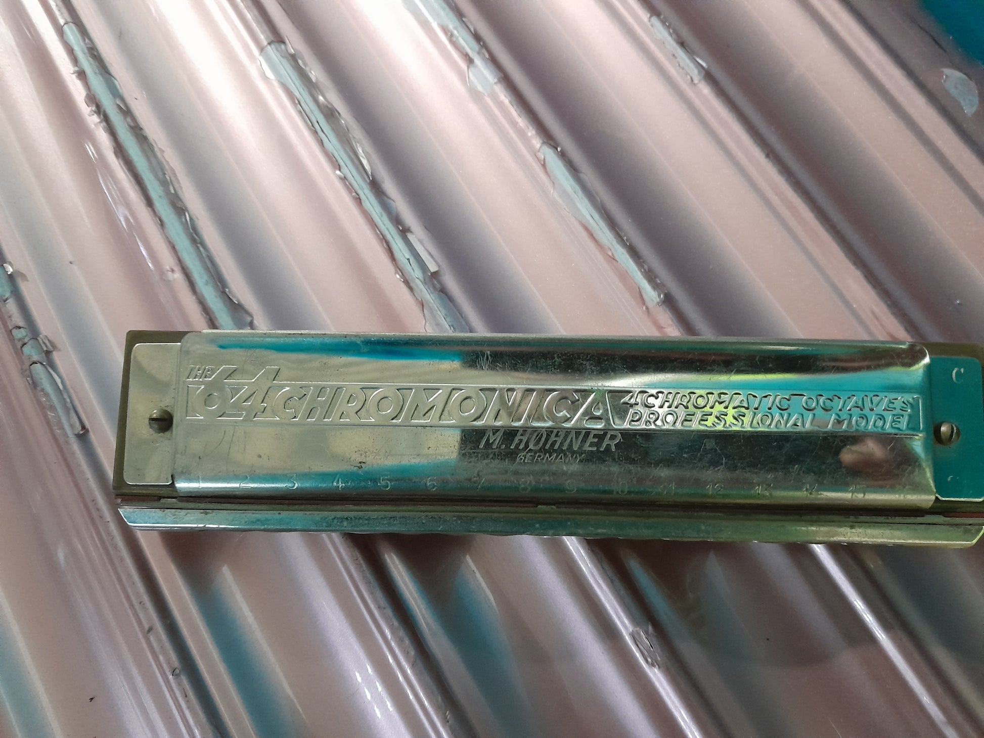 Hohner Chromonica 64 harmonica placed on a textured background, perfect for music enthusiasts.